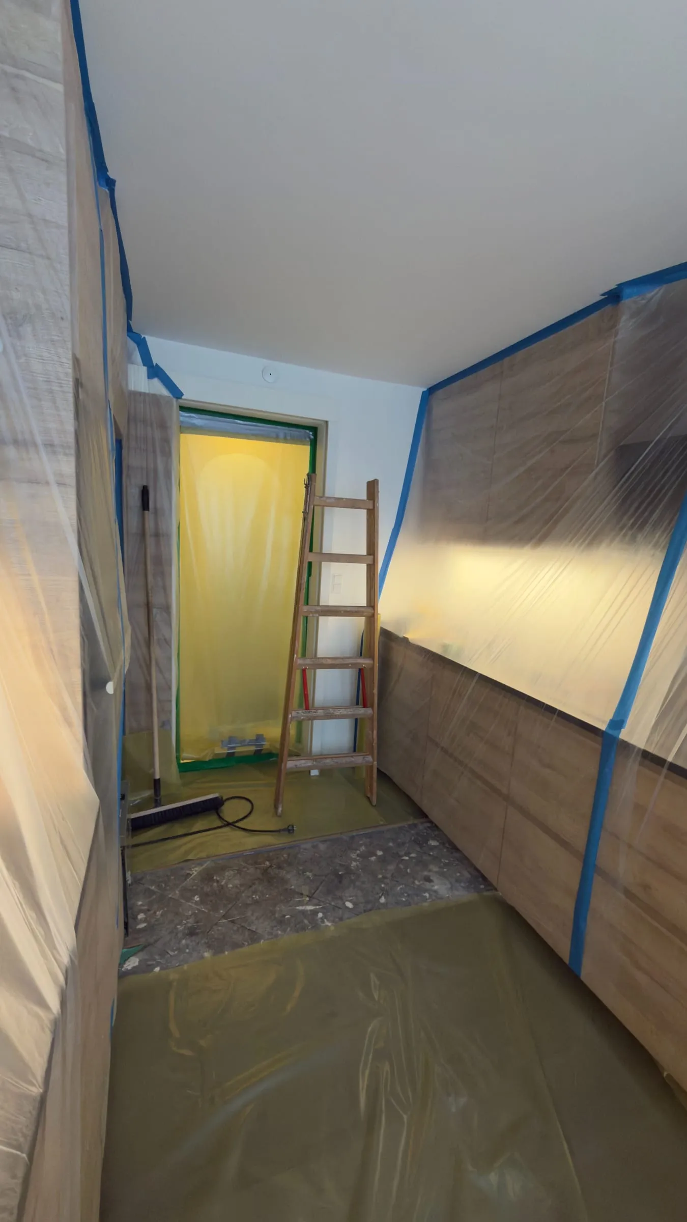 Afskærmet arbejdsområde med plastafdækning og sluse, klar til fjernelse af asbest